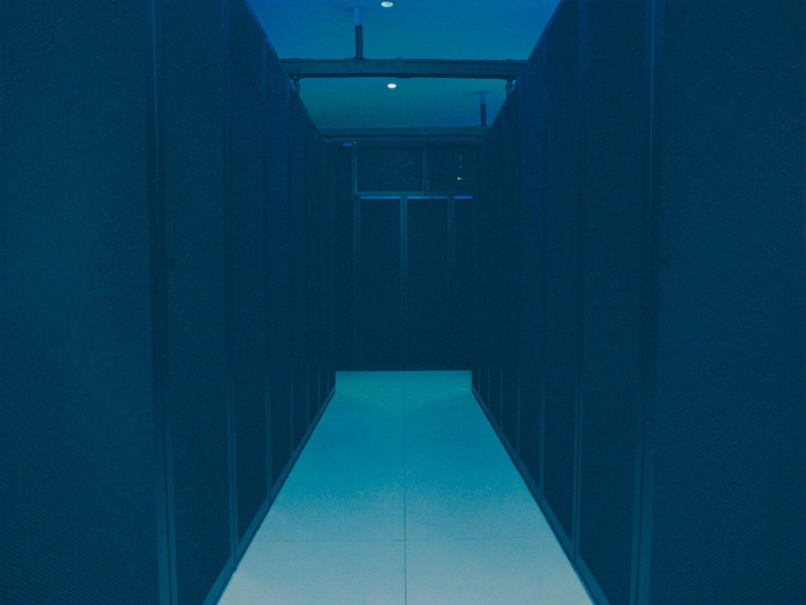 Corredor de data center com racks de servidores sob luz azul